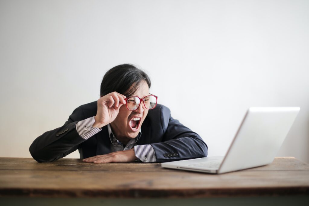 Immagine di un uomo che fatica a leggere dal computer